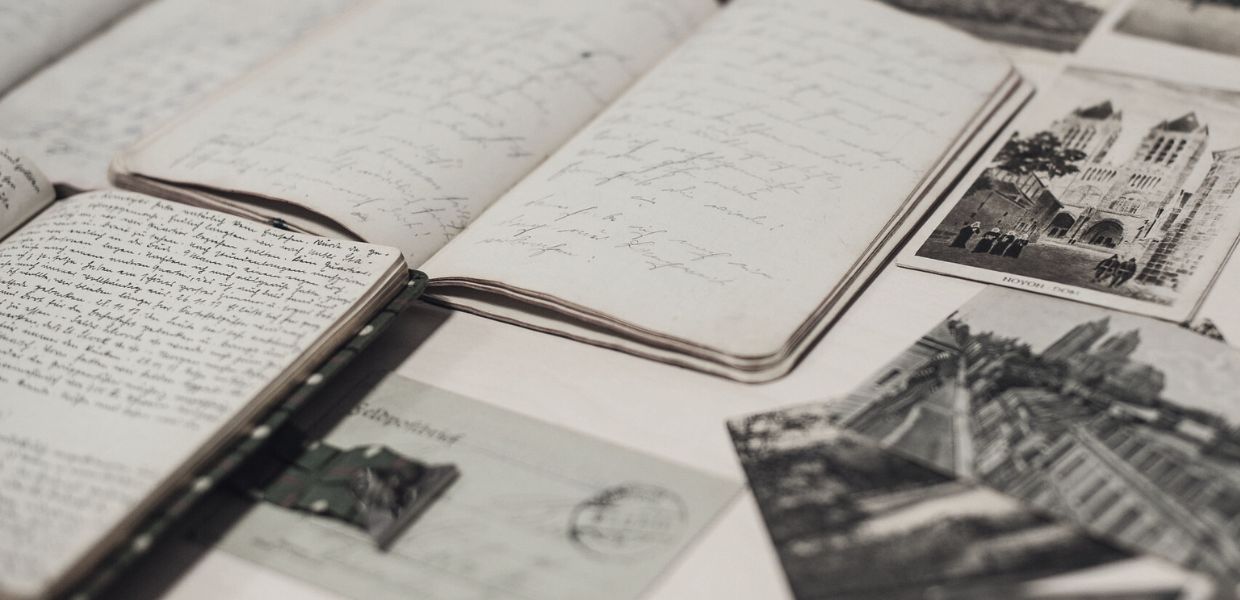 A black and white photo of notebooks and photos