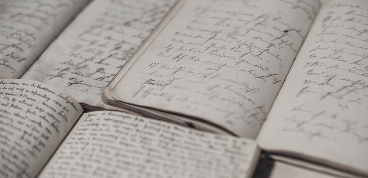A black and white photo of notebooks with writing in them
