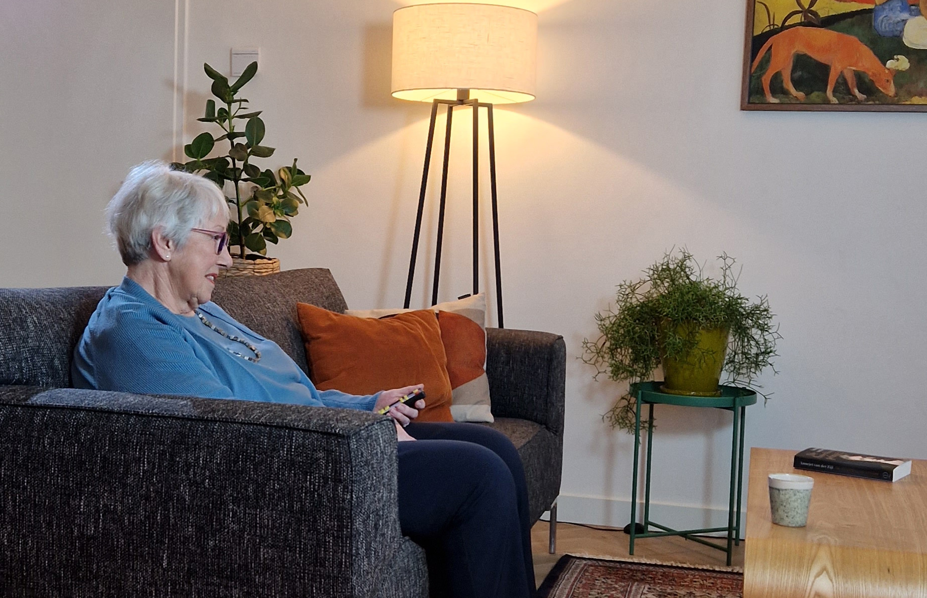 Vrouw kijkt tv vanuit zetel