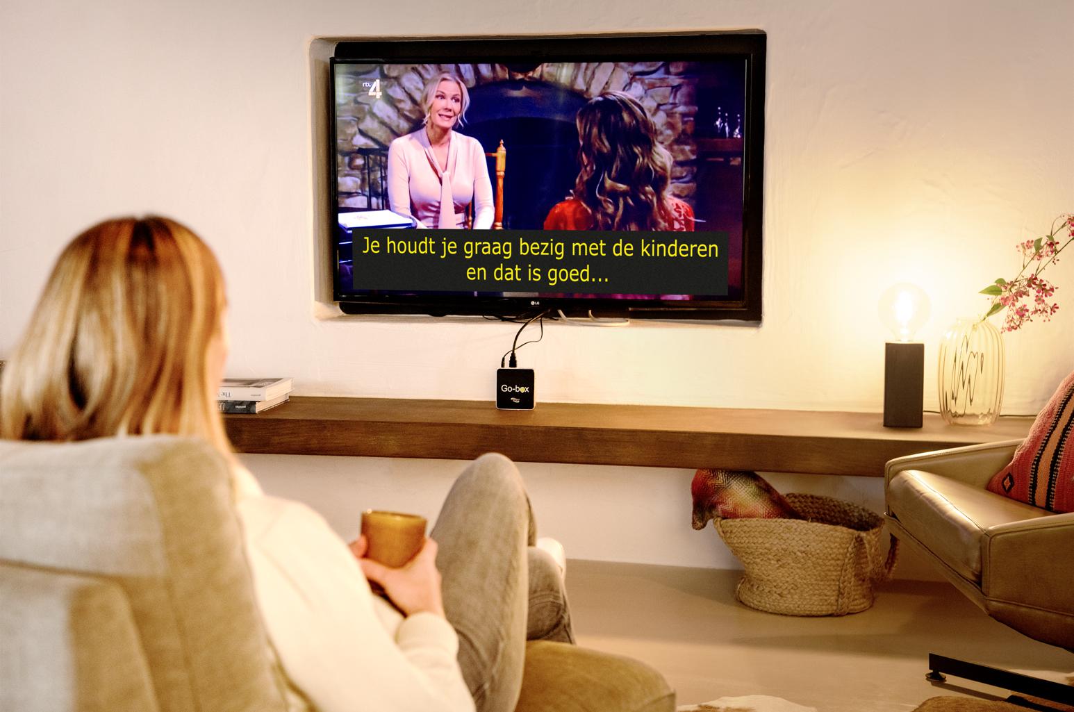Vrouw kijkt tv met vergrote ondertiteling