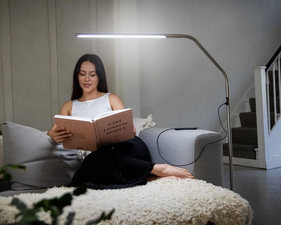 Vrouw die in de woonkamer een boek leest
