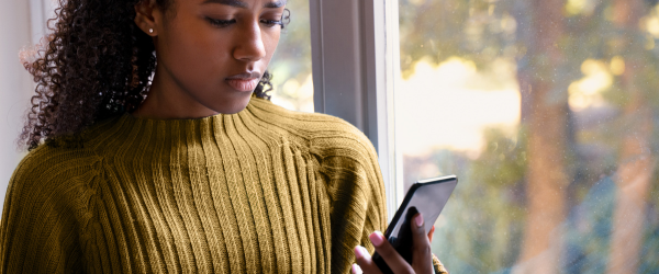 Vrouw kijkt bezorgd naar smartphone