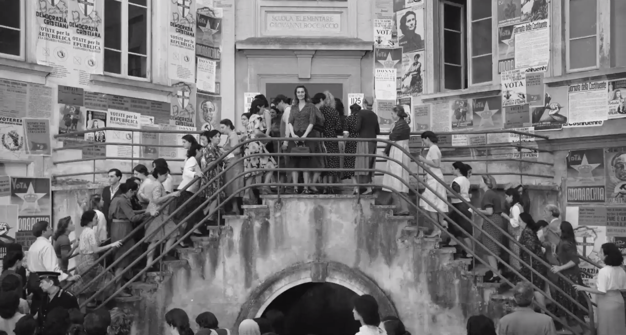 Scena tratta dal film C'&egrave; ancora domani di Paola Cortellesi che raffigura la protagonista in mezzo a una folla di donne come lei, che ha appena votato per la prima volta nella storia italiana.