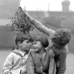 A schoolboy holding Mistletoe above the heads of his classmates