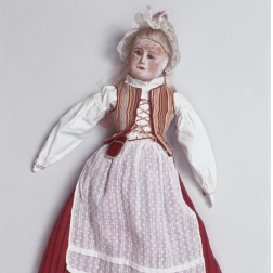 A wooden doll dressed in white and red