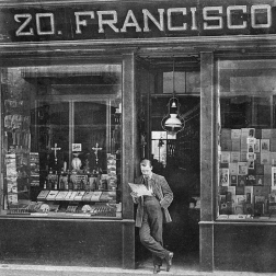 A black and white photo depicting a man in front of a bookshop